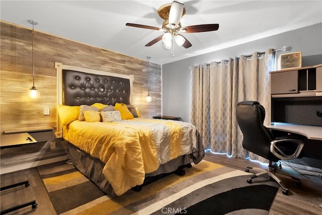 bedroom featuring dark wood-type flooring, ceiling fan, and wood walls