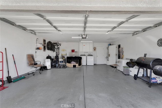 garage with washing machine and clothes dryer and a garage door opener