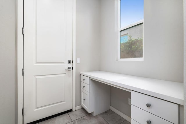 interior space featuring built in desk and light tile patterned floors