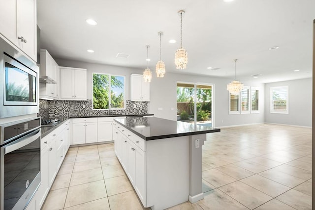 kitchen featuring appliances with stainless steel finishes, plenty of natural light, and a kitchen island