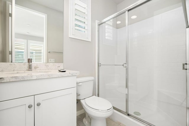 bathroom with vanity, tile patterned floors, toilet, and walk in shower