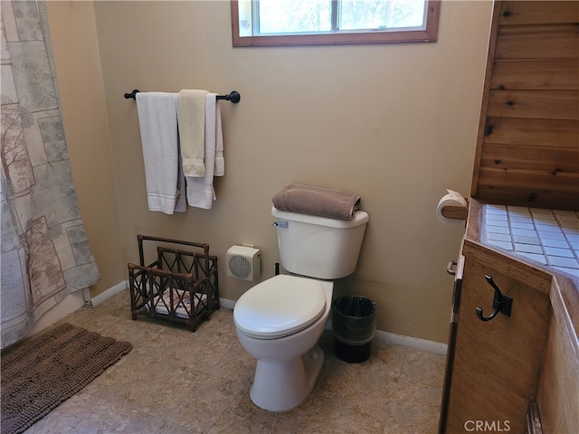 bathroom featuring a shower with curtain and toilet