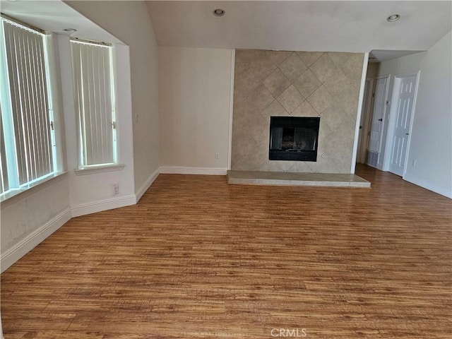 unfurnished living room featuring light wood-type flooring and a tile fireplace