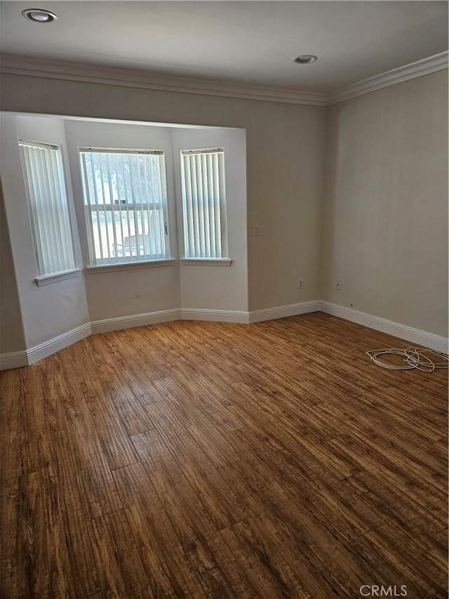 spare room featuring wood-type flooring and ornamental molding