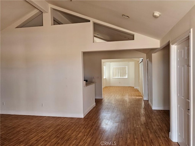 corridor featuring dark wood-type flooring and high vaulted ceiling