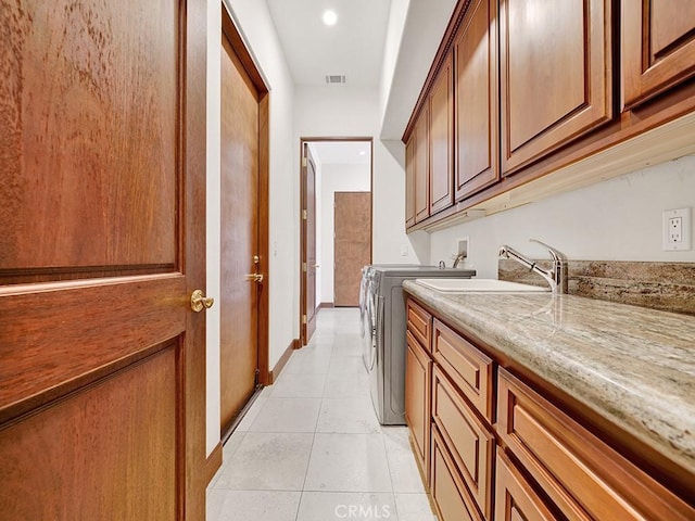 laundry room featuring cabinets, independent washer and dryer, sink, and light tile patterned floors