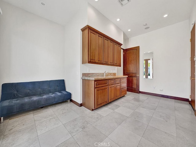 kitchen featuring light stone counters and sink