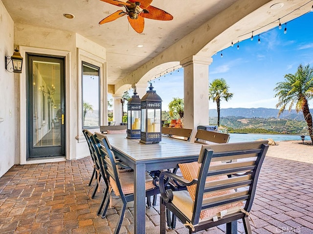 view of patio featuring ceiling fan and a water and mountain view