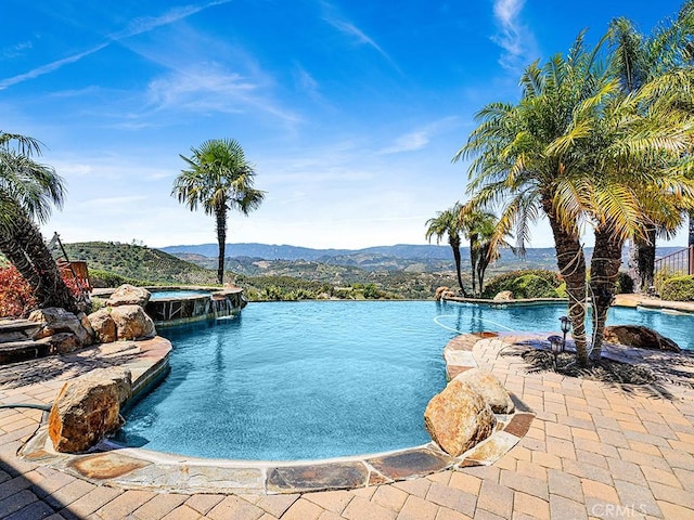 view of swimming pool featuring pool water feature and a mountain view