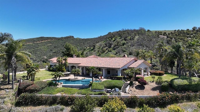 exterior space featuring a lawn, a mountain view, and a fenced in pool