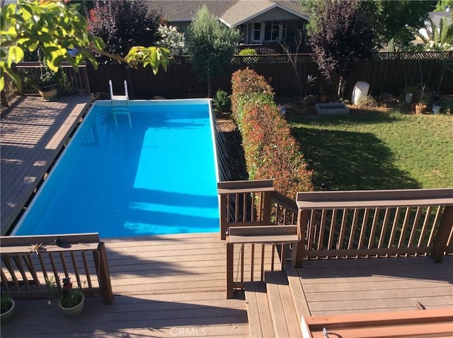 view of swimming pool with a lawn and a wooden deck