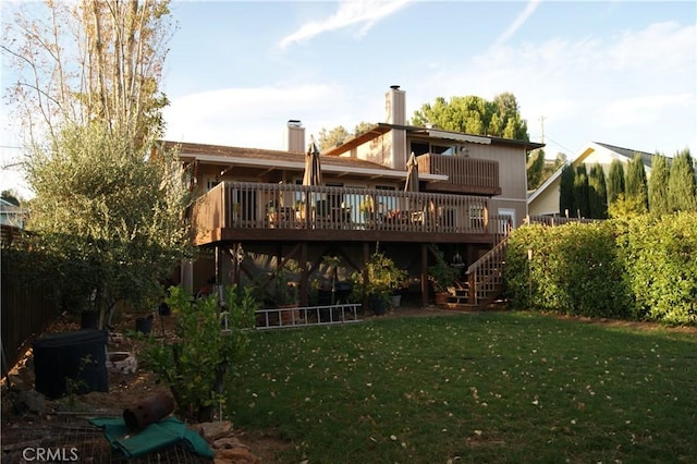 rear view of property featuring a lawn and a deck