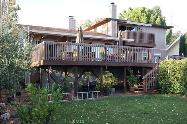 back of property featuring a lawn, a wooden deck, and a balcony