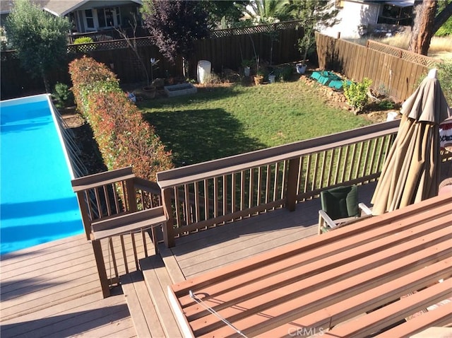 wooden terrace with a lawn and a fenced in pool