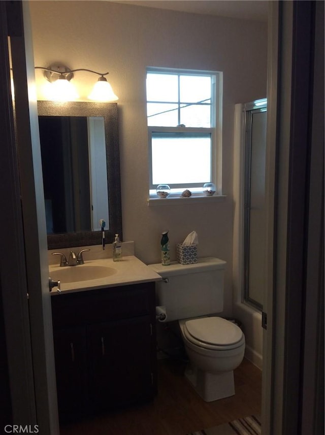 bathroom with vanity, toilet, wood-type flooring, and walk in shower