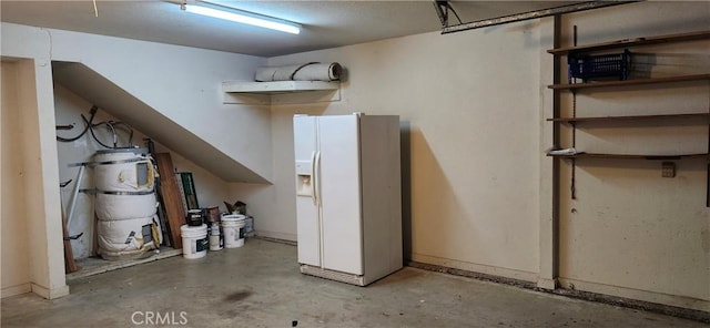 garage featuring white fridge with ice dispenser