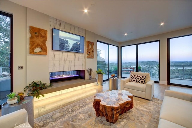 living room with hardwood / wood-style floors, a wealth of natural light, and a fireplace