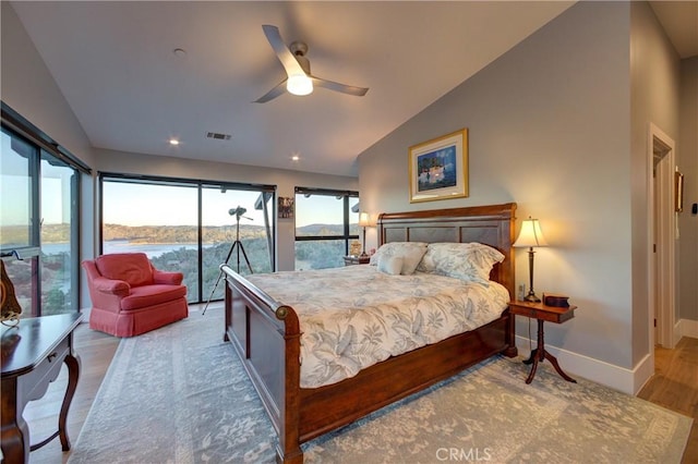 bedroom featuring lofted ceiling, ceiling fan, a water view, light hardwood / wood-style floors, and access to outside