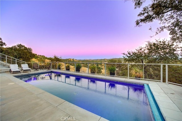 pool at dusk with a patio