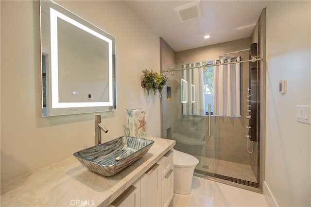 bathroom with vanity, toilet, and a shower with door