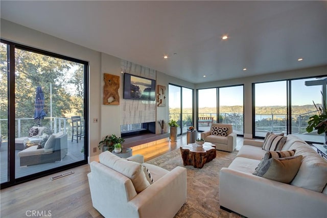 living room with a large fireplace and light wood-type flooring