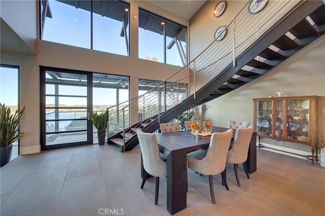 dining space with a water view and a towering ceiling