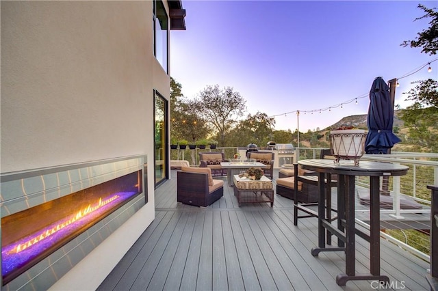 deck at dusk with an outdoor hangout area