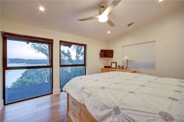 bedroom with vaulted ceiling, ceiling fan, and light wood-type flooring