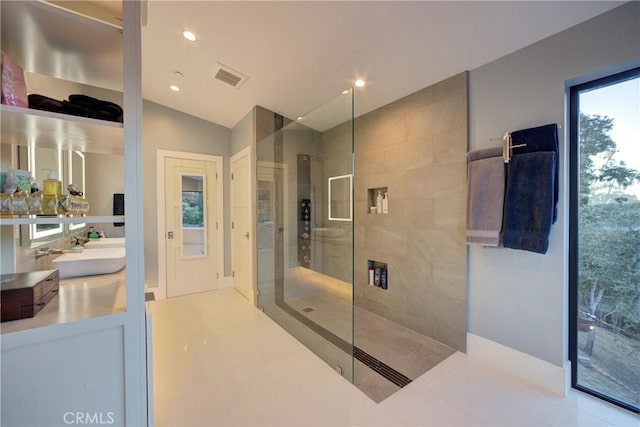 bathroom with vanity, lofted ceiling, and tiled shower