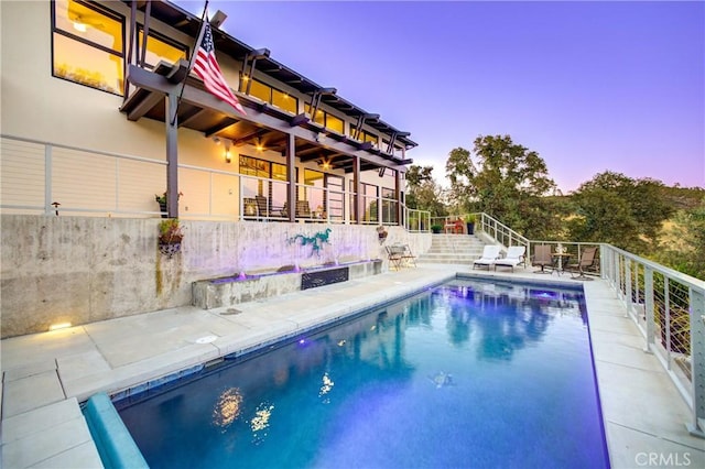 pool at dusk featuring a patio area