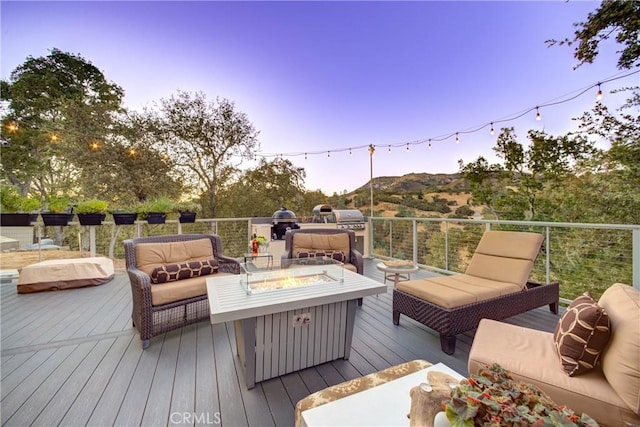 deck at dusk featuring an outdoor living space with a fire pit