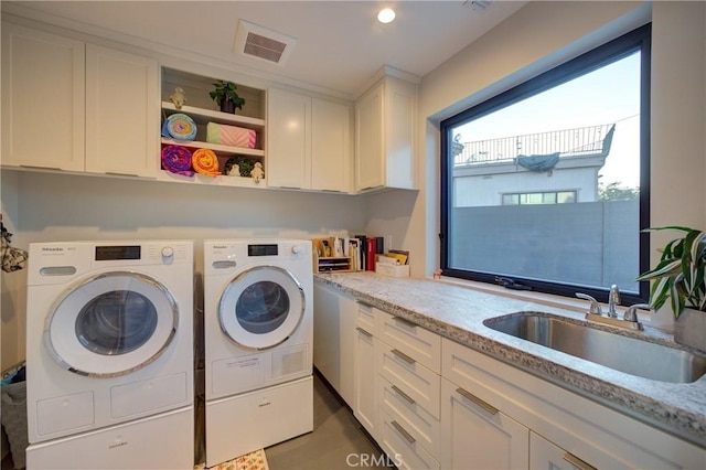 laundry area with sink, cabinets, and washing machine and clothes dryer