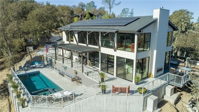 rear view of house featuring solar panels