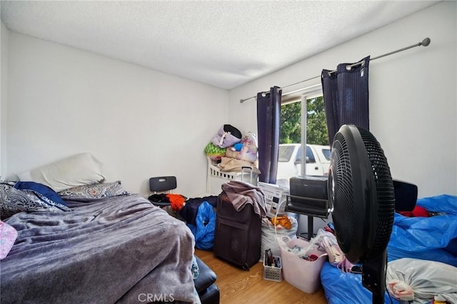 bedroom with light hardwood / wood-style floors and a textured ceiling