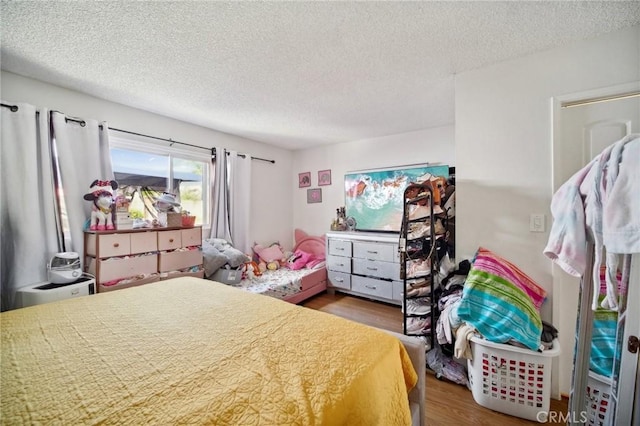 bedroom featuring wood-type flooring and a textured ceiling