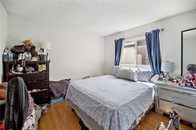 bedroom with hardwood / wood-style floors and a textured ceiling