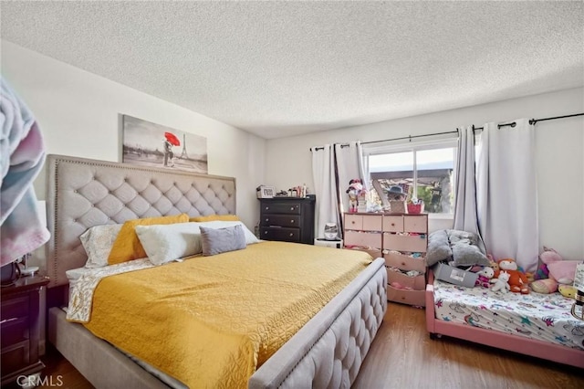 bedroom with hardwood / wood-style floors and a textured ceiling