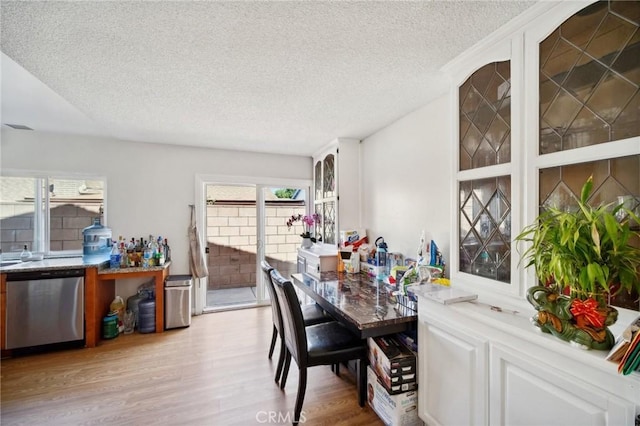 dining room featuring a textured ceiling and light hardwood / wood-style flooring