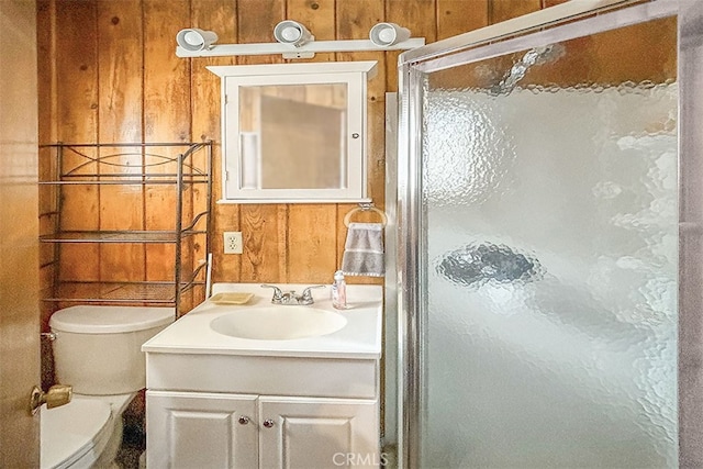 bathroom with vanity, wooden walls, toilet, and an enclosed shower