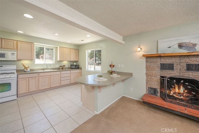 kitchen featuring kitchen peninsula, beam ceiling, light tile patterned floors, a textured ceiling, and white appliances