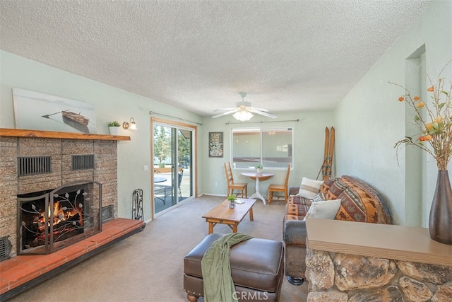 living room featuring ceiling fan, carpet flooring, a textured ceiling, and a fireplace