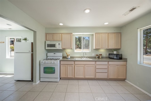 kitchen featuring light brown cabinets, sink, light tile patterned floors, and white appliances