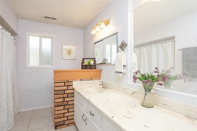 bathroom with vanity, a textured ceiling, and tile patterned flooring