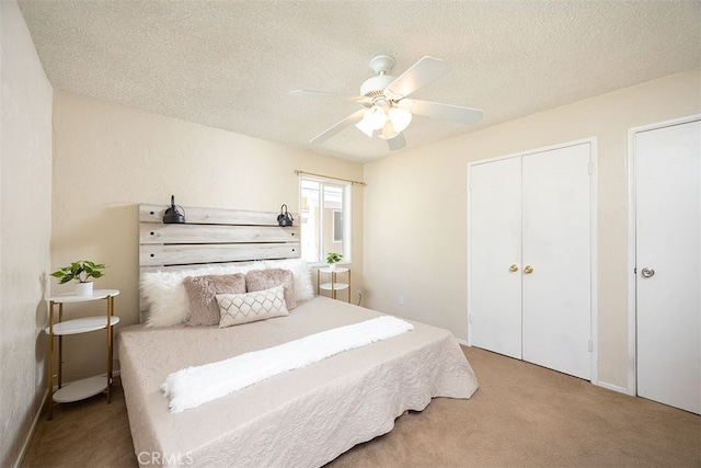 carpeted bedroom featuring a textured ceiling and ceiling fan