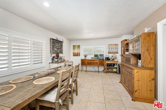 dining room featuring a textured ceiling and light tile patterned floors