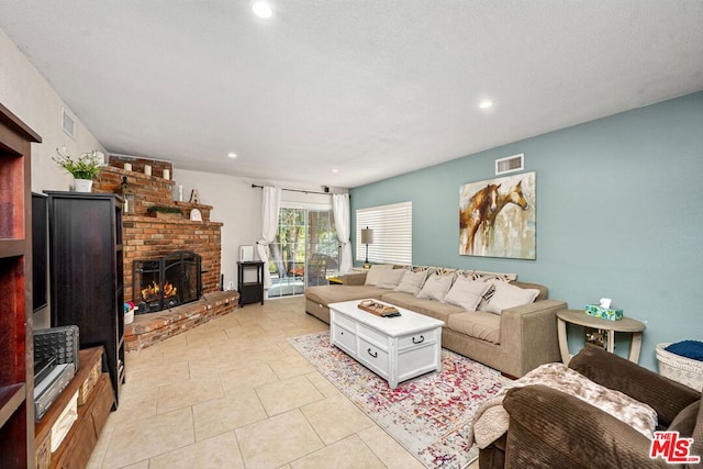 tiled living room with a textured ceiling and a fireplace