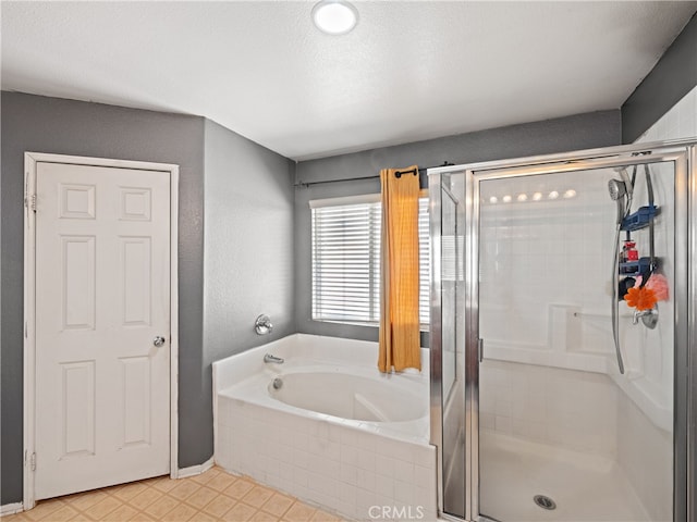 bathroom featuring a textured ceiling and separate shower and tub