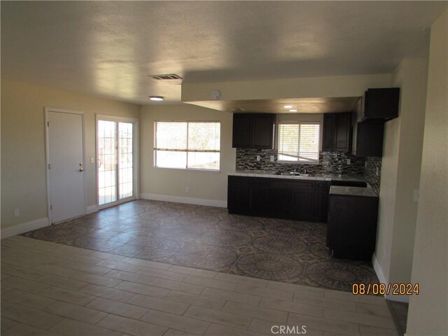 kitchen featuring light tile patterned floors and backsplash