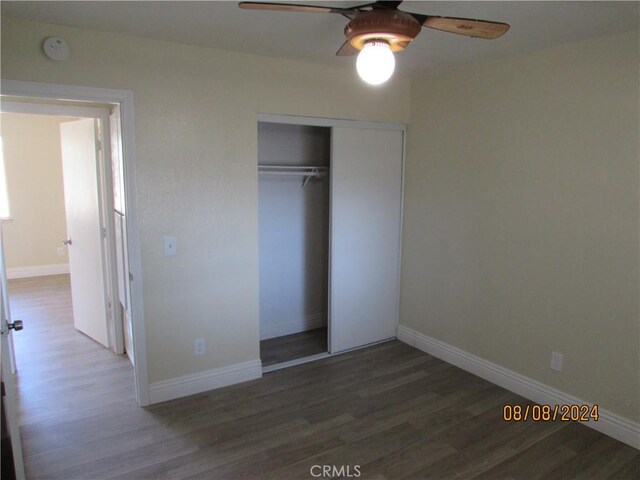 unfurnished bedroom featuring ceiling fan, a closet, and dark hardwood / wood-style floors