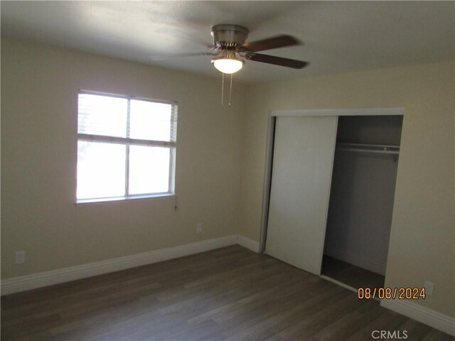 unfurnished bedroom with ceiling fan, a closet, and hardwood / wood-style flooring